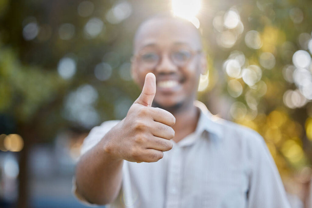 Black man, hands and thumbs up in park for success, good job or approval in the nature outdoors. Portrait of happy African male person show thumb emoji, yes sign or like for agreement or deal outside. - Foto, Imagem