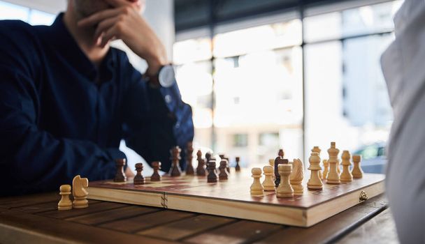 Настільна гра, шахи і чоловіки грають за столом в офісі, думаючи про стратегію або план. Чоловіки друзі разом грають, розслабляються і зв'язуються з дерев'яною піктограмою для вирішення проблем, конкуренції або контролера. - Фото, зображення