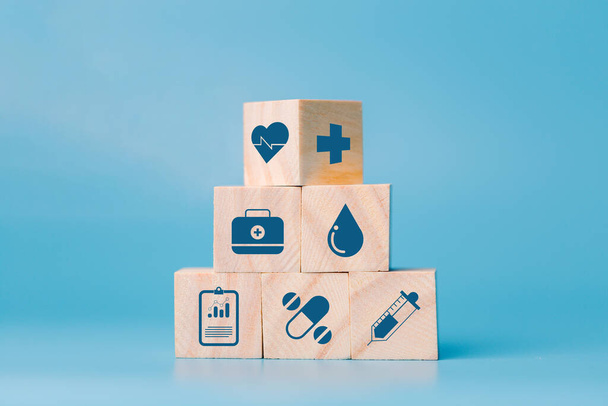 健康的で健康的なコンセプトのためのスクリーンヘルスケアと医療アイコンを印刷木製のブロックキューブを積層。メディアアイコンの概念を持つ医療や医療、木製のテーブルのスタックから木製のキューブ. - 写真・画像