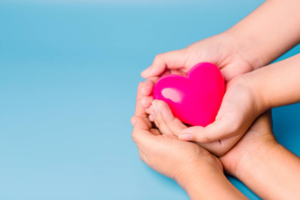 pleeggezin concept. handen houden rood hart, gezondheidszorg, liefde, orgaandonatie, mindfulness, welzijn, familie verzekering en MVO concept, wereld hart dag, wereld gezondheidsdag, wereld geestelijke gezondheid dag. - Foto, afbeelding