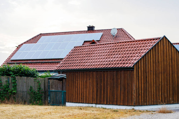Casa de madera con paneles solares instalados. Energía alternativa, ahorro de recursos y concepto de estilo de vida sostenible. - Foto, Imagen