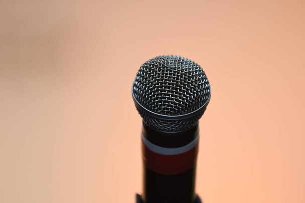 Микрофон с пьедесталом в окружении с изолированным фоном из огней и цветов - Фото, изображение