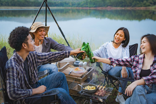 Camp party in the evening with a bonfire. Have fun cooking barbecued food. - Photo, image