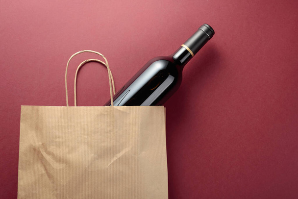リサイクル紙のショッピングバッグには赤ワインが入っています。トップビュー、コピースペース. - 写真・画像
