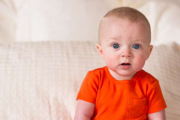 Μικρά μπλε Eyed βρέφος αγόρι κάθεται κοιτάζοντας σε κάμερα - Φωτογραφία, εικόνα