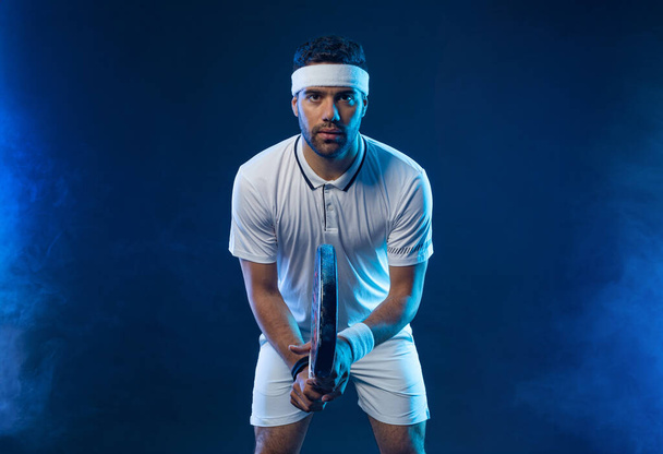 Padel tennis player with racket. Man athlete with racket on court with neon colors. Sport concept. Download a high quality photo for the design of a sports app or betting site - Photo, image