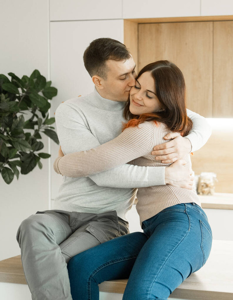 A young couple in love hugging at modern kitchen. Love concept. - Fotografie, Obrázek