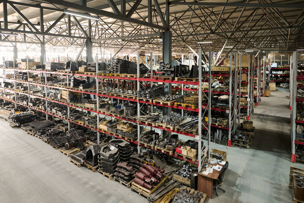 Ευρύχωρη αποθήκη του σύγχρονου βιομηχανικού εργοστασίου παραγωγής τεράστιων κατασκευαστικών μηχανών ή άλλου εξοπλισμού ή ανταλλακτικών - Φωτογραφία, εικόνα
