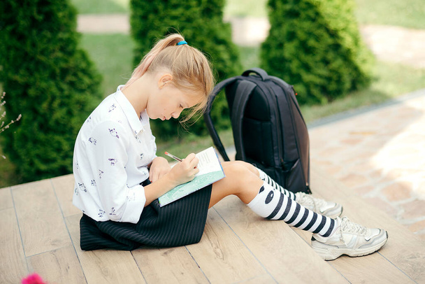 Okuldaki ilk günüm. Okula dönelim. Kitap yığınında oturan tatlı liseli kız. Boşluğu Kopyala - Fotoğraf, Görsel