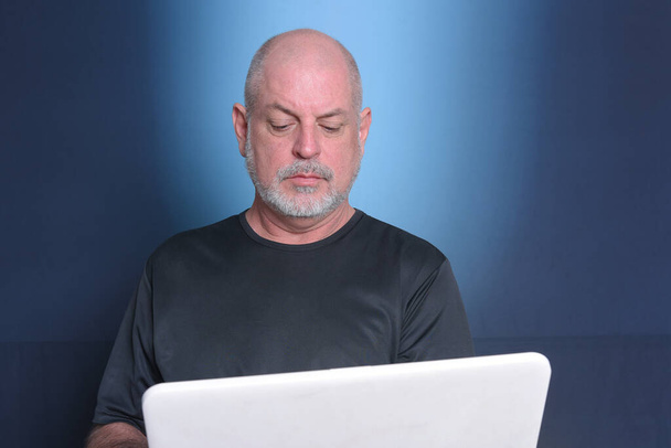 hombre adulto que utiliza el ordenador portátil uso de la tecnología de la comunicación y el servicio "S3niorLife". - Foto, imagen