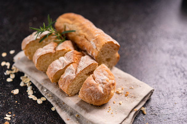 Sliced baguette bread on wooden coaster and rustic background. Artisan Sourdough bread. - Φωτογραφία, εικόνα