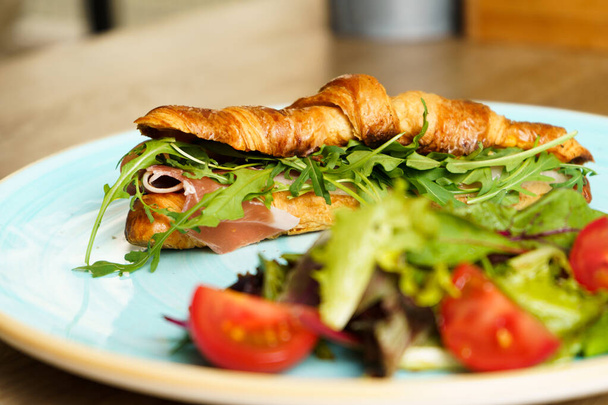 Croissant with ham, vegetables and cheese. - Foto, imagen