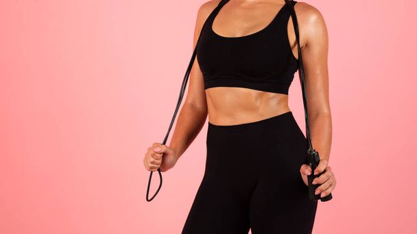 Fitness Concept. Unrecognizable Fit Lady Posing With Jump Rope, Young Woman In Sportswear Standing Over Pink Studio Background, Enjoying Healthy Lifestyle And Sport Workouts, Panorama With Copy Space - Foto, Imagen