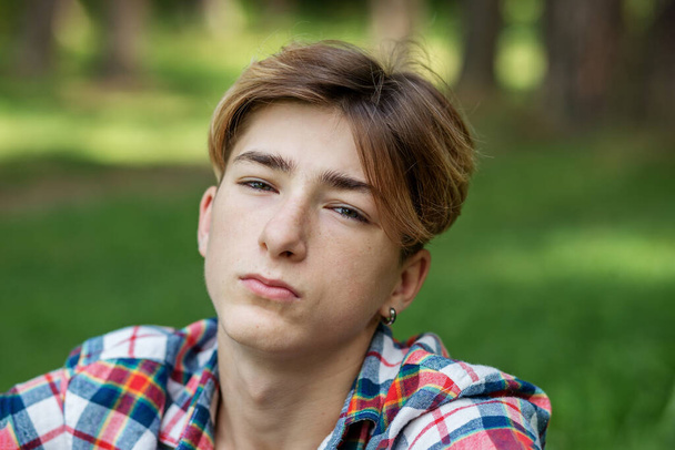 Close-up portret van een tiener jongen buiten. Generaal Z. Identiteitsontwikkeling. Ongelukkig en stress. - Foto, afbeelding