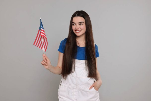 4th of July - Independence Day of USA. Happy girl with American flag on grey background - Foto, Imagem