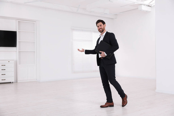 Happy real estate agent showing new apartment - Foto, imagen