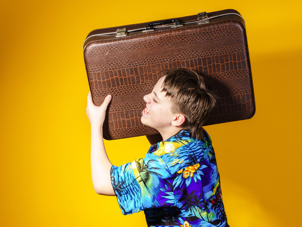 Affective teenage boy with retro suitcase - Foto, afbeelding