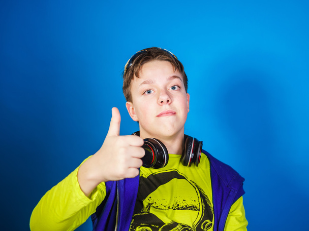 Affective teenage boy listening music in headphones - Foto, Bild