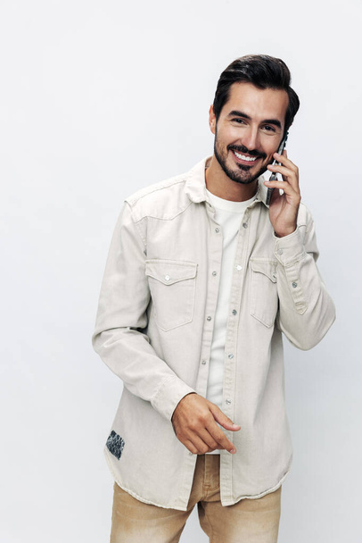 Closeup portrait man talking on the phone smiling and laughing happiness communication on white isolated background, fashionable clothing style, copy space, space for text. High quality photo - Photo, Image