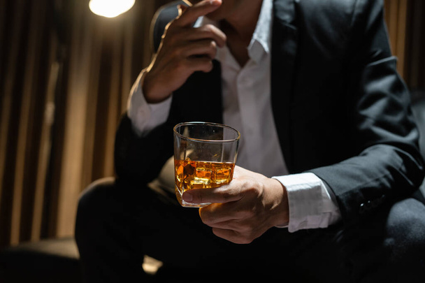 Businessman sitting Holding a Glass of Whiskey Drink Whiskey in the liquor store room - Photo, image