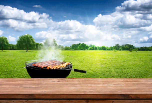 summer time outdoors with grill BBQ, wooden table, blurred background - Photo, Image