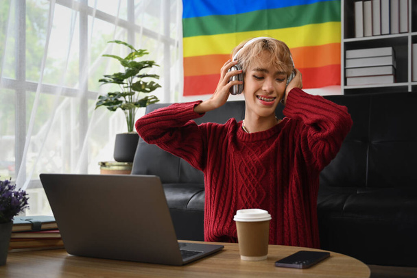 Carefree teenage gay man enjoying favorite track, listening to music on headphones. LGBTQ people lifestyle concept. - Photo, Image