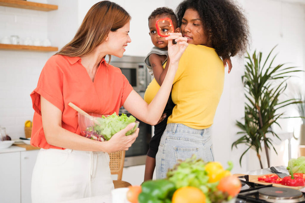 Coppia lesbica con il loro piccolo bambino in cucina - Foto, immagini