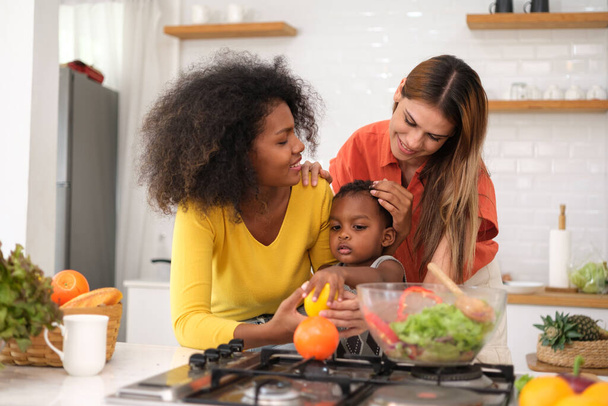 Coppia lesbica con il loro piccolo bambino in cucina - Foto, immagini