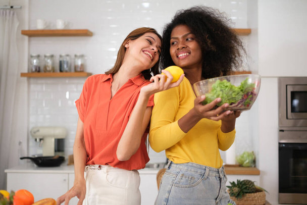 Multiracial pareja lesbiana cocina ensalada en kitche - Foto, imagen