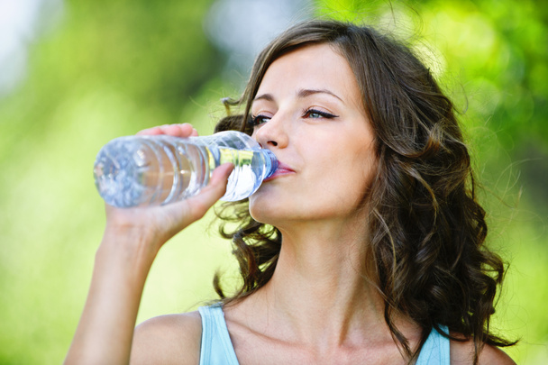 Jeune femme aux cheveux bruns boire de l'eau
 - Photo, image