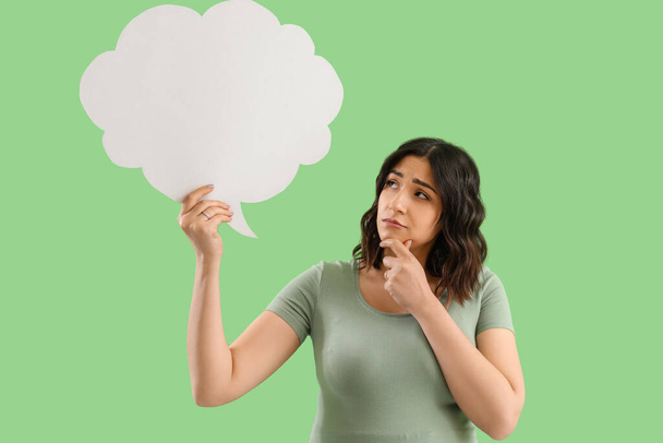 Gondolkodó fiatal terhes nő üres beszéd buborék zöld háttér - Fotó, kép