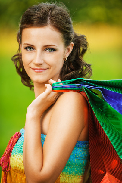 Portrait of young smiling woman holding many bags - Photo, Image