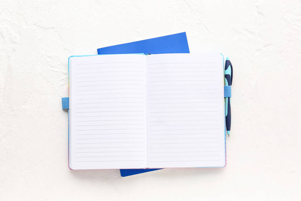 Blanco open notitieboek met pen op lichte achtergrond - Foto, afbeelding
