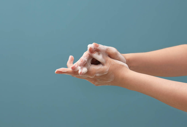 Hands in soap foam on blue background - Foto, imagen