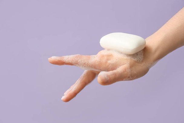 Hand with soap on lilac background - Zdjęcie, obraz