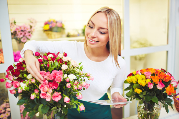 Kukkakauppias huolehtii kukkia
 - Valokuva, kuva