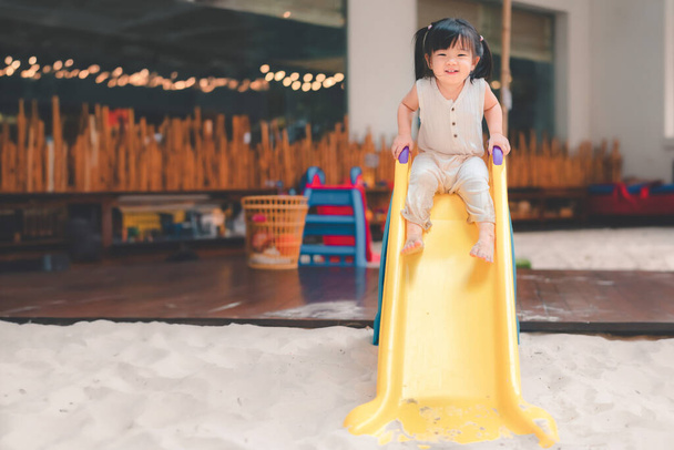 Asian girl play slider at outdoor playground, Cute child happy preschool little kid having funny while playing,  Learning and active of kids concept. - Foto, Imagen