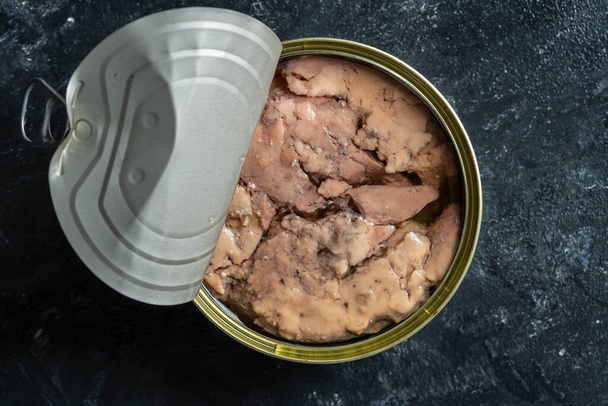 Open tin can with cod liver on wooden table background, close up, top view - Photo, image