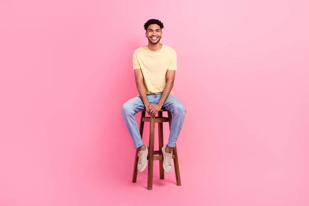 Full length photo of young applicant man wear t-shirt denim jeans sitting bartender chair waiting his turn isolated on pink background. - Foto, Imagem
