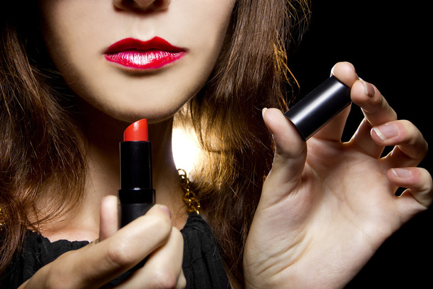 Female putting on red lipstick - Foto, afbeelding