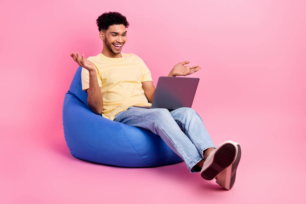 Full length cadre of laughing positive good mood guy sit dorm room with netbook skype call with parents isolated on pink color background. - Valokuva, kuva