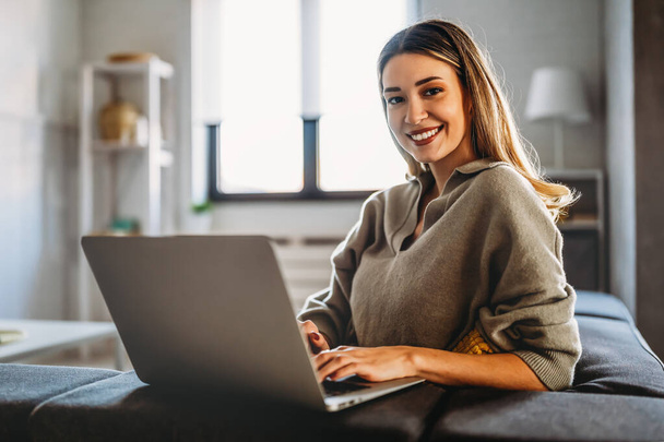 Smiling pretty woman using laptop for work freelance social media or relaxation. People technology concept. - Foto, Imagem