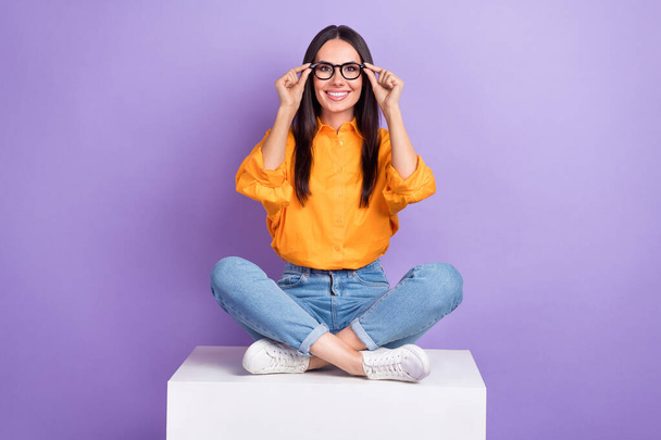 Full size photo of good mood woman dressed yellow shirt jeans hands touching glasses at checkup isolated on violet color background. - Foto, imagen