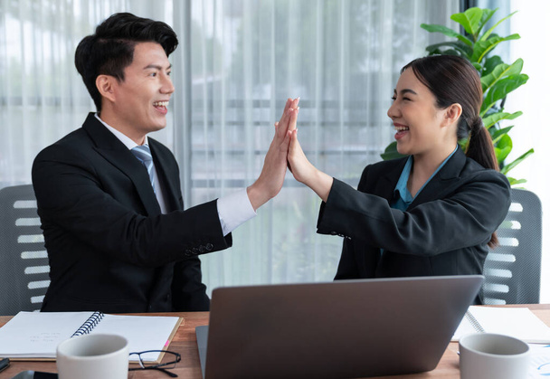 Asian business colleague celebrate successful meeting with high-fives and expressions of happiness in corporate office meeting represent unity success and professional teamwork integrity. Jubilant - Foto, Bild