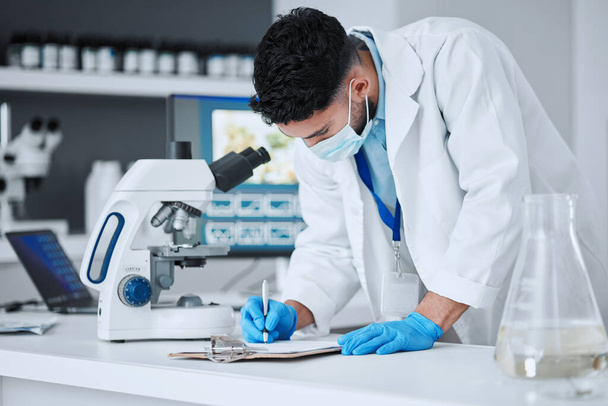 Research, writing and science with man in laboratory for report, pharmacy and medical. Checklist, healthcare and medicine with scientist and clipboard for data chart, vaccine development and study. - Photo, Image