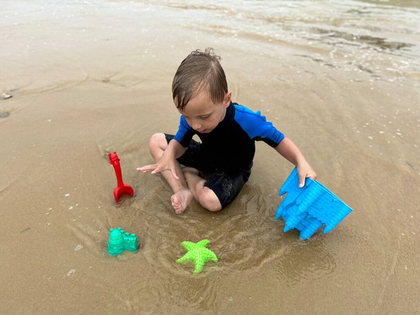 poika etsii aarteita rannalta, metallinpaljastimella - Valokuva, kuva