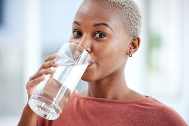 Sıvı, sağlık ve sıvı diyeti için su içen bir kadının sağlık, cam ve portresi. Sağlıklı, H2O ve evinde soğuk bir içecek ya da içecek içen genç Afrikalı kadın portresi. - Fotoğraf, Görsel