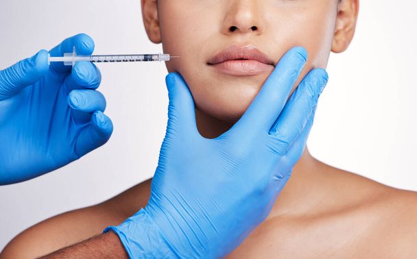 Hands, injection and face with collagen, studio and cosmetic surgery for beauty, change and lip filler by white background. Surgeon, syringe and facial transformation for patient, service or skincare. - Φωτογραφία, εικόνα