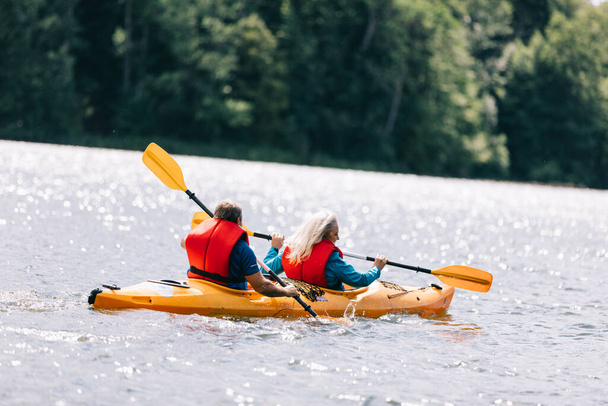 Felice anziano coppia attiva kayak sul lago godendo del tempo insieme - Foto, immagini