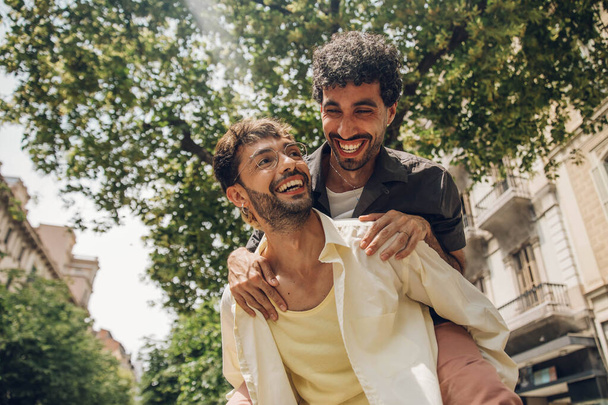 Dva mladí muži si povídají a smějí se v zahradě. Muži se spolu baví. - Fotografie, Obrázek